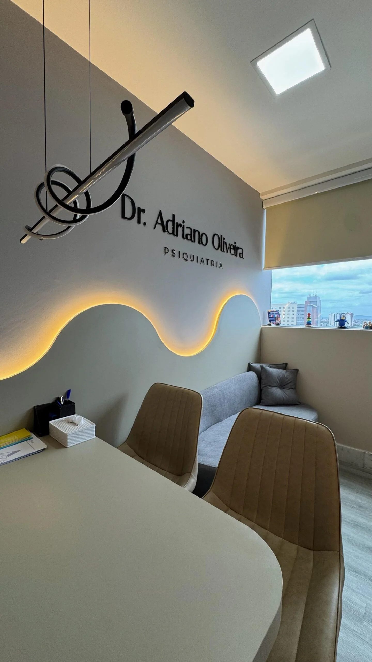 Consultório do Dr. Adriano Oliveira com iluminação âmbar e parede ondulada